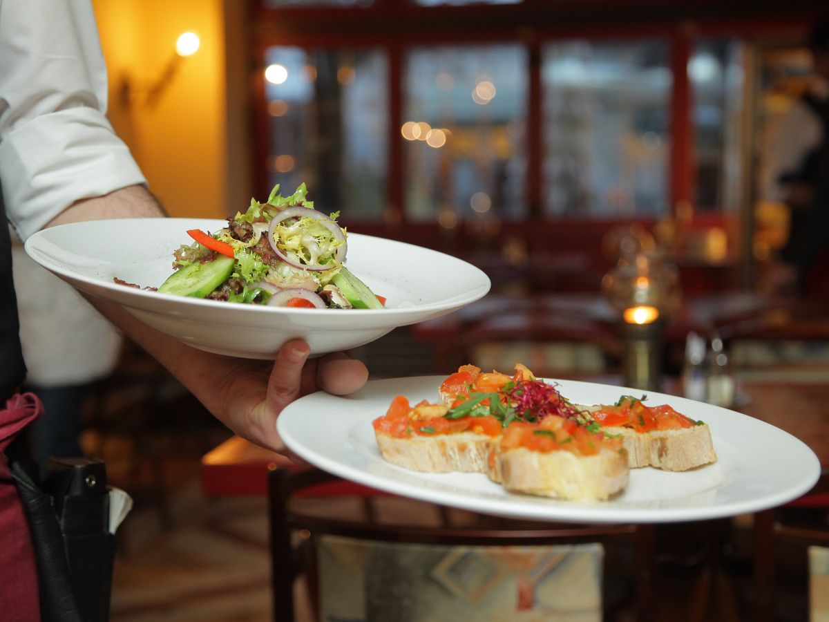 Chef Ananya Mehta plating a seasonal dish in the open kitchen